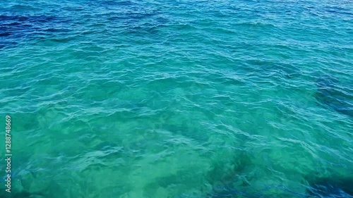 Beautiful blue sea and large calm waves .