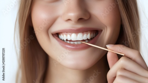 Woman using wooden toothpick for cleaning teeth after meal