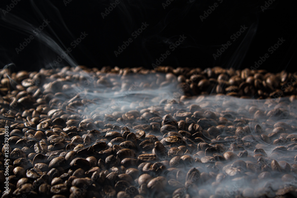 Obraz premium Freshly roasted coffee beans with smoke on black background