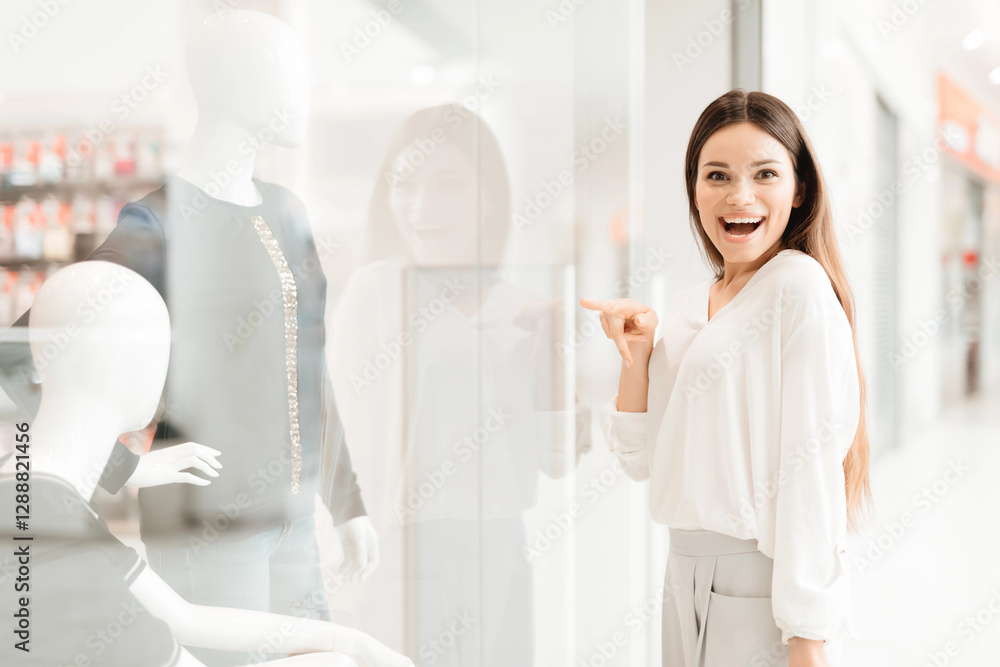 Woman in shopping mall. Girl is standing near store window looking at new dress. Woman in shopping mall. Girl is standing near store window looking at new dress.