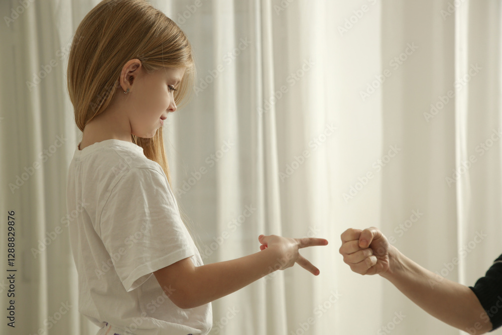 Mother and daughter playing a fun scissors paper rock game in the bedroom Mother and daughter playing a fun scissors paper rock game in the bedroom