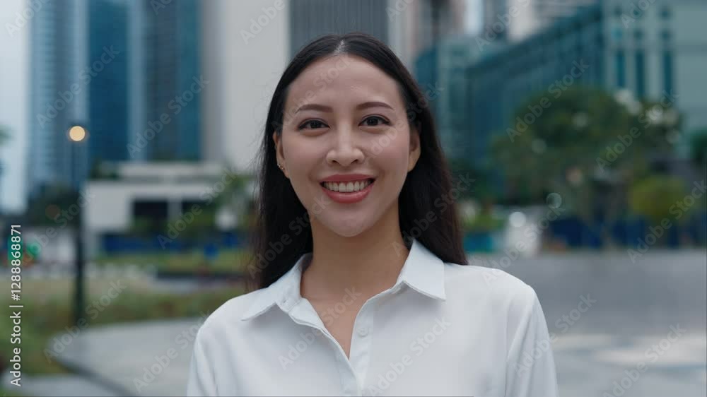 Portrait of the Young Smiling Charming Business Lady Standing Outside Wearing Formal Clothes. Attractive Asian Girl in Official Attire Outdoors Posing to the Camera with Positive Face. People Concept Portrait of the Young Smiling Charming Business Lady Standing Outside Wearing Formal Clothes. Attractive Asian Girl in Official Attire Outdoors Posing to the Camera with Positive Face. People Concept