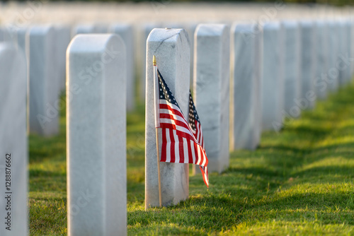 фотографія American national military cemetery with rows of white tomb stones and USA flag on green grass lawn
