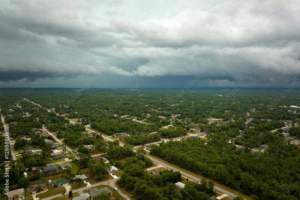Fotografie Dark stormy clouds forming on gloomy sky before heavy rainfall over suburban tow