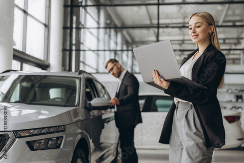 Wallpaper Mural Female salesperson or manager with laptop and male customer choosing a car inside a car dealership Torontodigital.ca