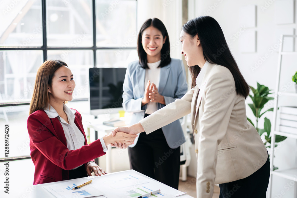 Three women shaking hands in a business setting Three women shaking hands in a business setting