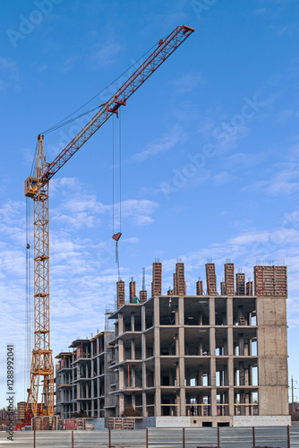 Construction site of a modern building with a crane and blue sky