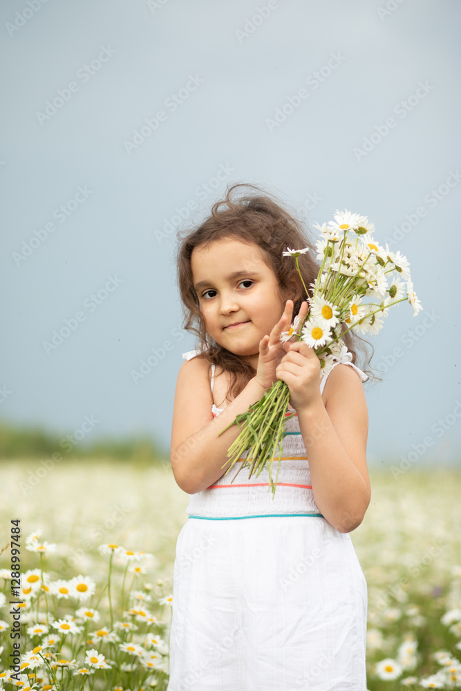 Cute little child girl at chamomile field picking flowers Cute little child girl at chamomile field picking flowers