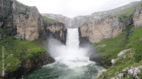 Majestic waterfall cascading between cliffs, green landscape background; nature travel