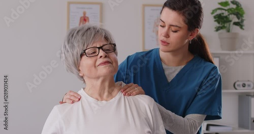 Wallpaper Mural Young female doctor, nurse or caregiver is massaging the neck and back of a senior female patient in the hospital, providing rehabilitation, physiotherapy care and medical therapy. Torontodigital.ca