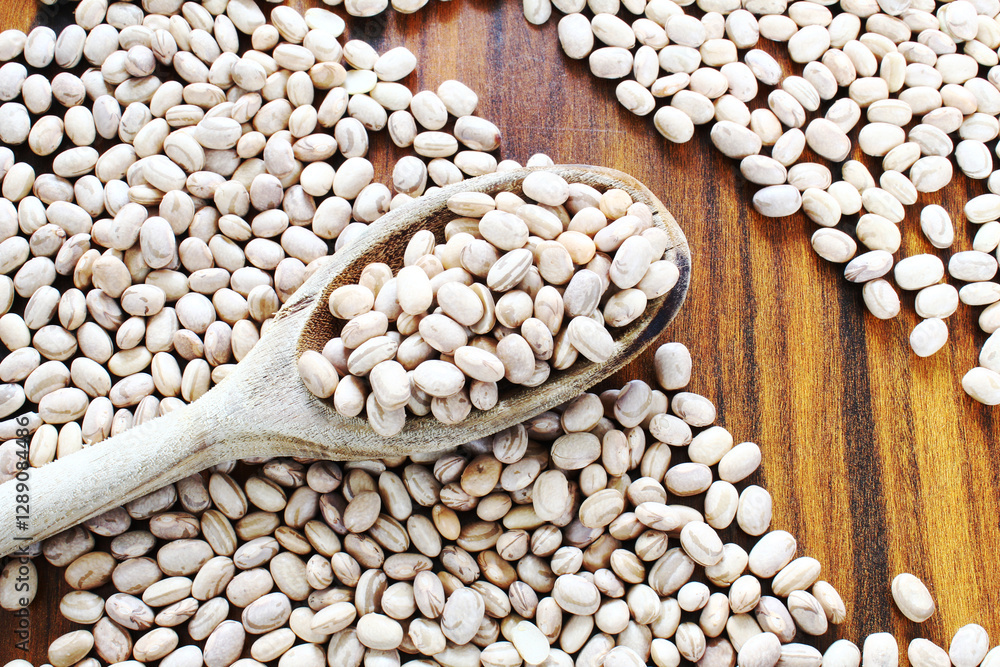 Obraz premium Pinto beans scattered on the wooden table. Carioca beans.