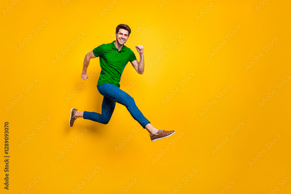 Full length body size phoo of cheerful brown haired attractive man wearing blue pants trousers purple t-shirt footwear aspiring jumping running isolated over yellow vivid color background Full length body size phoo of cheerful brown haired attractive man wearing blue pants trousers purple t-shirt footwear aspiring jumping running isolated over yellow vivid color background