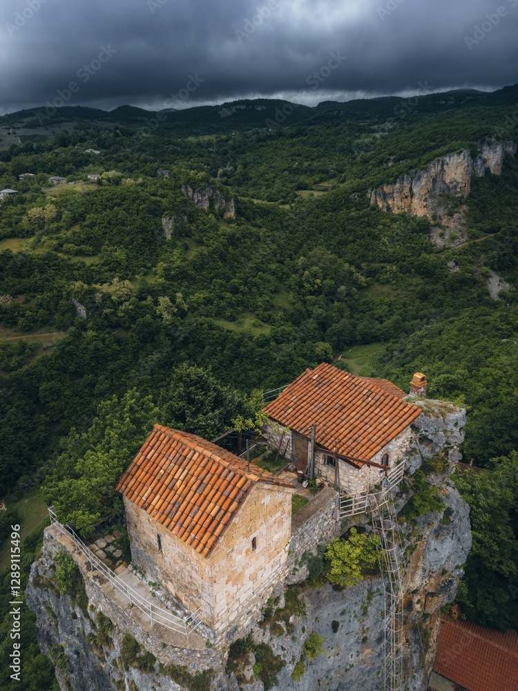 forest covered gorge and house on a rock pillar, cliff house on top, aerial view forest covered gorge and house on a rock pillar, cliff house on top, aerial view
