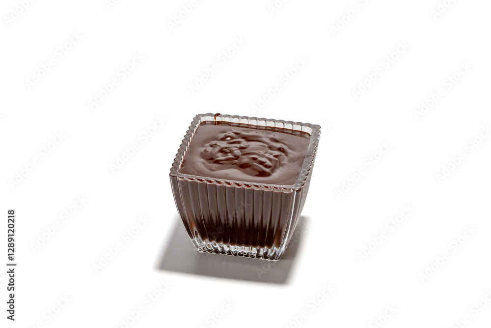 A small square of chocolate is sitting in a glass bowl. The bowl is clear and has a square shape A small square of chocolate is sitting in a glass bowl. The bowl is clear and has a square shape