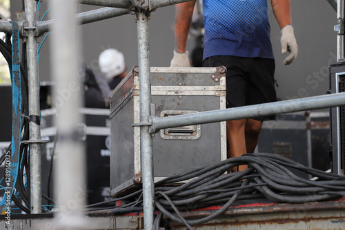 Operator transporting box of equipment in stage setup