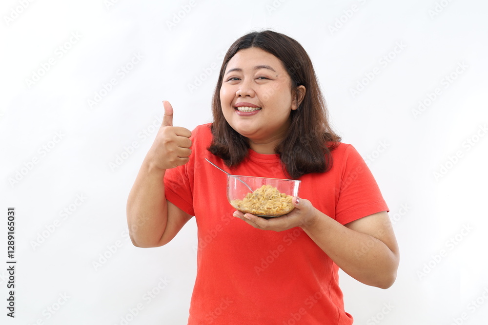 Young Asian woman enjoying fried noodles while giving a thumbs-up or OK sign, isolated on a white background. Perfect for advertising, promotions, or food-related content. Young Asian woman enjoying fried noodles while giving a thumbs-up or OK sign, isolated on a white background. Perfect for advertising, promotions, or food-related content.