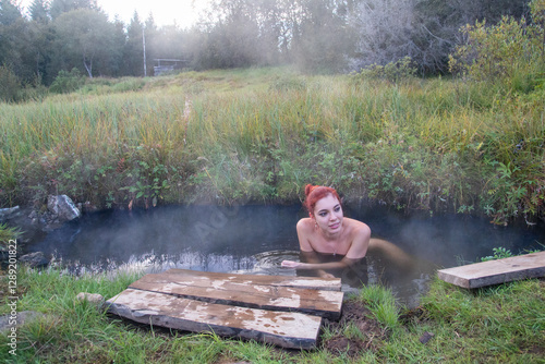 Beautiful woman bathing nude at Iceland hot springs, Kualaug hot pool and misty nature around