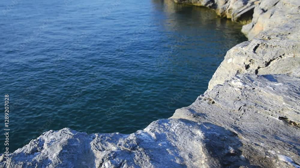 ripple on sea surface and wind in gray curve stone cliff bay under sunlight, relaxing with seascape tranquility scenery ripple on sea surface and wind in gray curve stone cliff bay under sunlight, relaxing with seascape tranquility scenery
