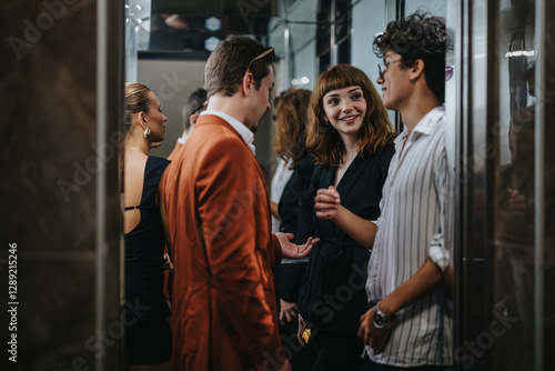 Принти на полотні A group of young professionals engaged in casual conversation inside a modern elevator