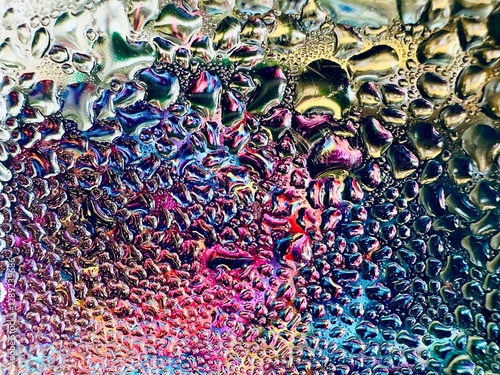 Close-up of water drops on metal surface in high resolution showing condensation of water droplets on metal surface. Intricate patterns and different sized water droplets create a beautiful abstract