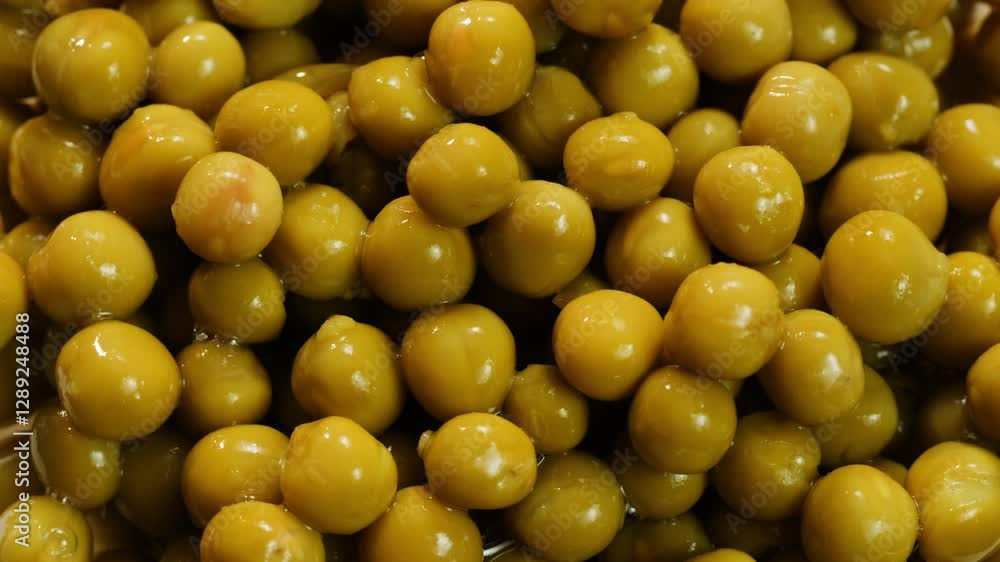 Marinated pickled sweet green peas canned food, rotation in circle. Take canned green pea kernels with a fork Marinated pickled sweet green peas canned food, rotation in circle. Take canned green pea kernels with a fork