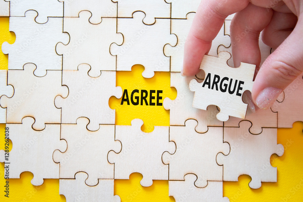 Agree or Argue symbol. Concept word Agree or Argue on wooden puzzle. Businessman hand. Beautiful yellow background. Business and Agree or Argue concept. Copy space Agree or Argue symbol. Concept word Agree or Argue on wooden puzzle. Businessman hand. Beautiful yellow background. Business and Agree or Argue concept. Copy space