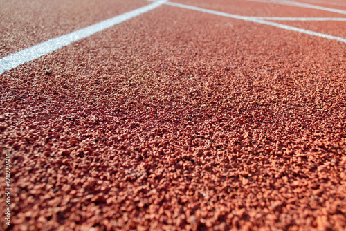 Running track at competition stadium. White stripe on red carpet going into the distance. White stripe on red carpet, close-up.