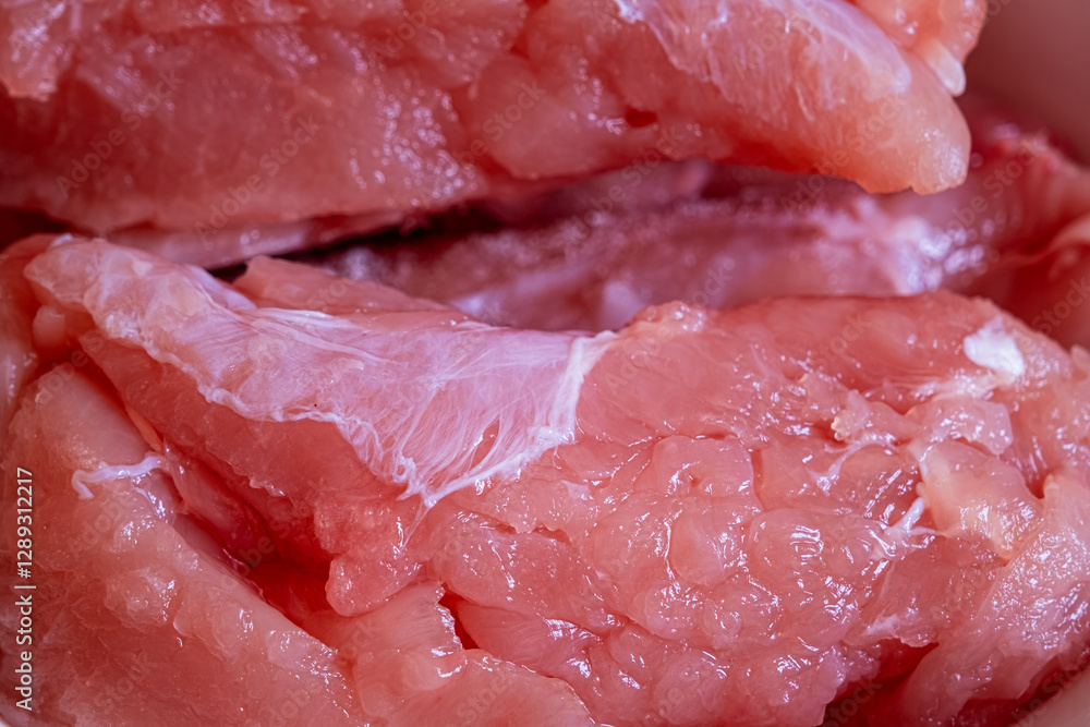 Close-up of pieces of uncooked fresh raw chicken fillet Close-up of pieces of uncooked fresh raw chicken fillet