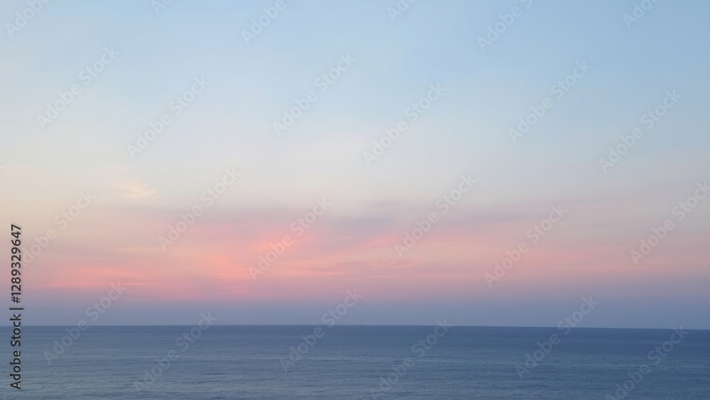 Fototapeta premium Soft pastel sunset over the calm ocean, with gentle hues of pink, purple, and blue blending in the sky. The tranquil scene captures the serene beauty of nature.