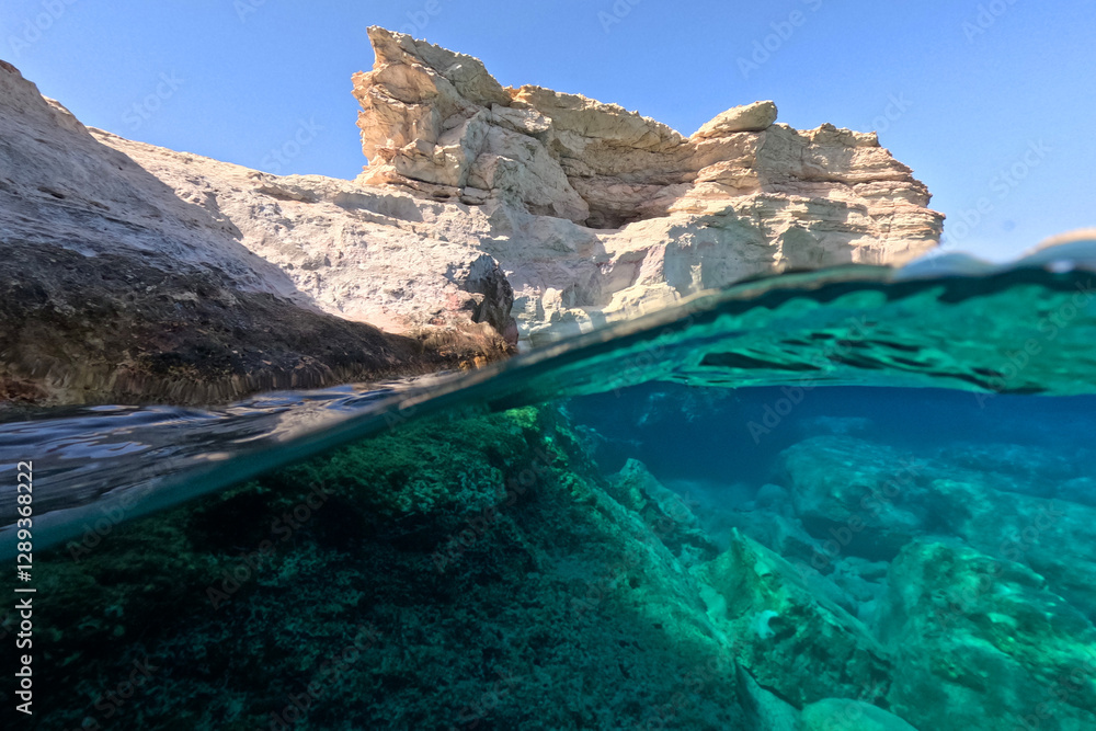 Obraz premium Underwater split photo of small cove of Goupa Kara famous for colourful boat houses called Sirmata, Kimolos island, Cyclades, Greece