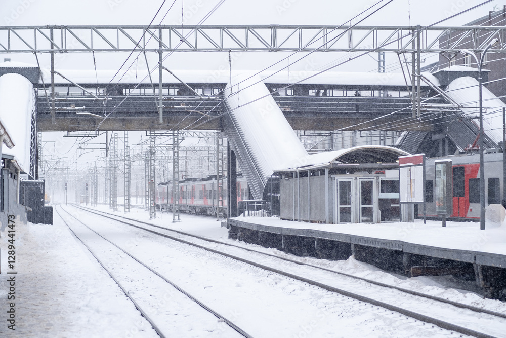 Fototapeta premium Snow covered railway station with snowstorm effects during winter morning hours