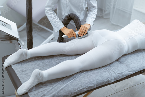 Woman relaxing during LPG endermologie massage session performed by smiling therapist in beauty salon