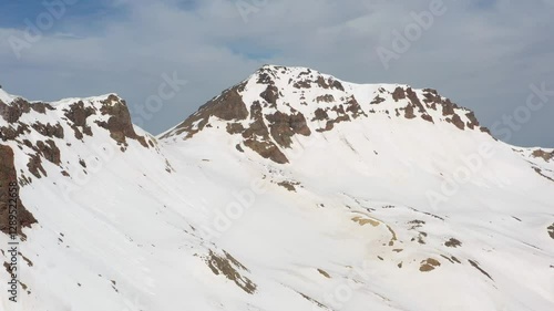 Wallpaper Mural 4K aerial drone footage of the snow-covered summits of Mount Aragats, the highest peak in Armenia, with its crater in spring. Breathtaking views of rugged highlands, glaciers, and remote wilderness. Torontodigital.ca