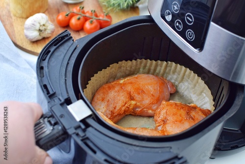 Cooking chicken legs in air fryer, using a disposable paper insert.