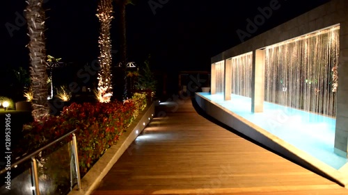 Waterfall fountain and palm tree in night illumination at the luxury hotel, Halkidiki, Greece