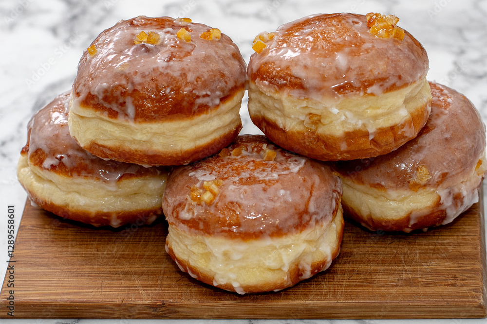 Freshly baked Polish doughnuts (paczki) with a golden-brown crust, glazed with icing and sprinkled with powdered sugar and candied orange peel. A traditional Fat Thursday treat full of flavor. Freshly baked Polish doughnuts (paczki) with a golden-brown crust, glazed with icing and sprinkled with powdered sugar and candied orange peel. A traditional Fat Thursday treat full of flavor.