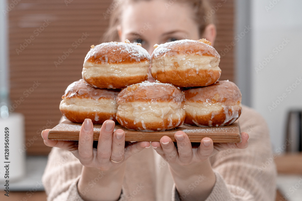 A cozy home setting with fresh Polish doughnuts (paczki) being sprinkled with powdered sugar. Soft, golden-brown pastries with icing and candied orange peel, perfect for Fat Thursday celebrations. A cozy home setting with fresh Polish doughnuts (paczki) being sprinkled with powdered sugar. Soft, golden-brown pastries with icing and candied orange peel, perfect for Fat Thursday celebrations.