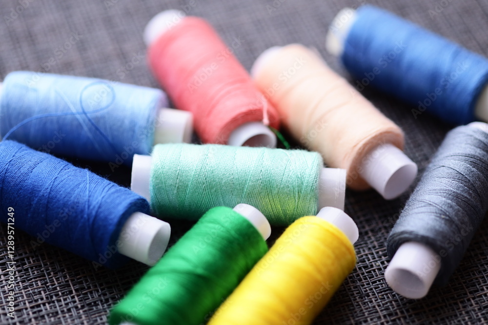 A collection of thread spools arranged neatly on a table, suitable for craft or sewing projects. A collection of thread spools arranged neatly on a table, suitable for craft or sewing projects.