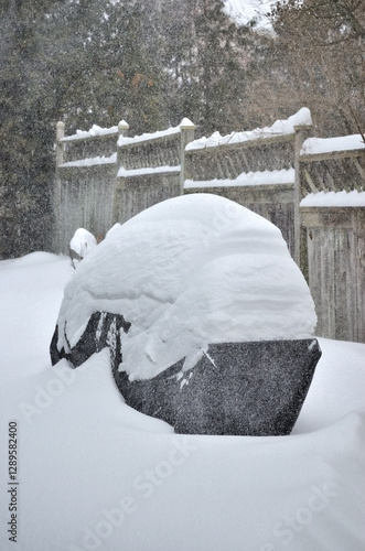 3/4 frame view of a Snow covered barbeque in a backyard snowfall