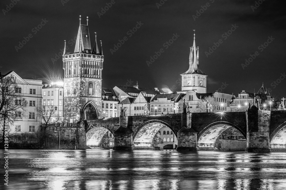 The illuminated Charles Bridge spans the Vltava River at night, showcasing stunning Gothic architecture. Reflections shimmer on the water, creating a serene atmosphere in Prague. The illuminated Charles Bridge spans the Vltava River at night, showcasing stunning Gothic architecture. Reflections shimmer on the water, creating a serene atmosphere in Prague.