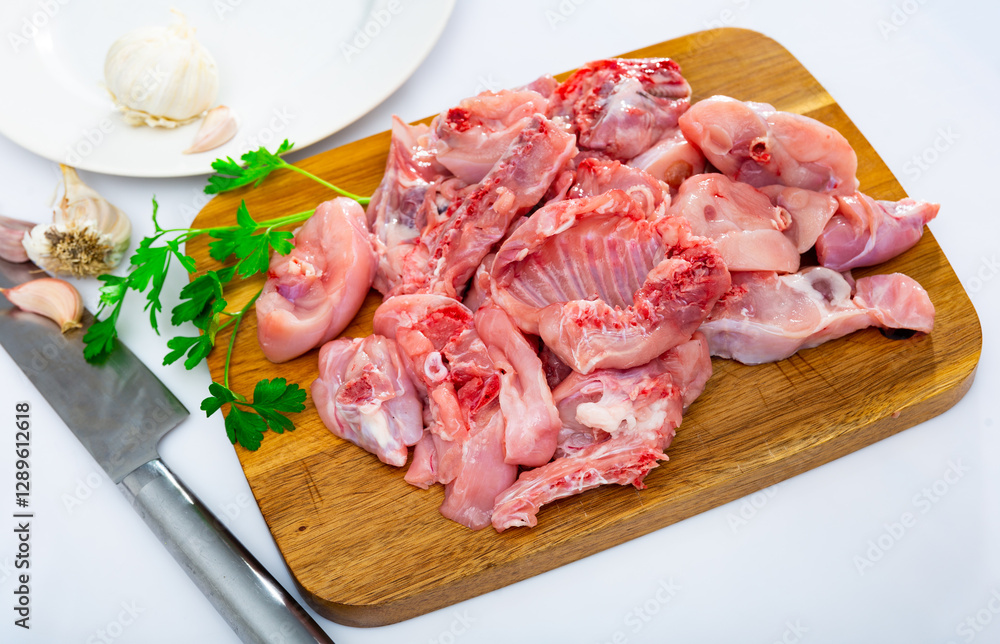Raw rabbit meat with spices and herbs on wooden cutting board Raw rabbit meat with spices and herbs on wooden cutting board