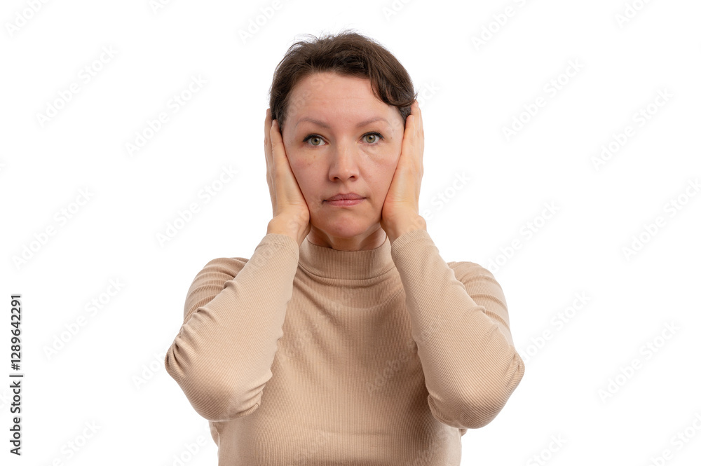 A woman with a neutral expression covering her ears with her hands against a white background. A woman with a neutral expression covering her ears with her hands against a white background.
