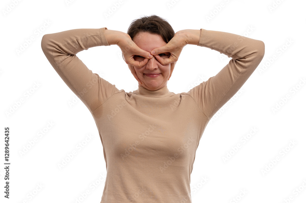 A young woman playfully making a funny face with her hands against a white background. A young woman playfully making a funny face with her hands against a white background.