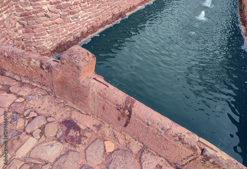 Historic Stone water channel with flowing water. A rustic stone water channel with gently flowing water. Turkiye, Konya, Sille. photo