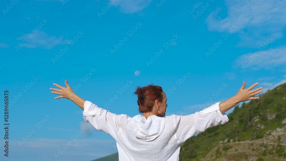 Alone lady travel to europe hills freedom. A lady traveler with open hand stand on the hill against blue sunny sky. Alone lady travel to europe hills freedom. A lady traveler with open hand stand on the hill against blue sunny sky.