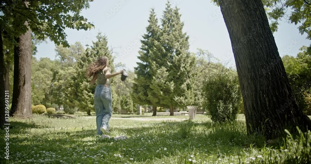 Young woman enjoying a sunny day in the park, tossing her bag playfully. She's relaxed, happy, and embracing the summer vibes. Young woman enjoying a sunny day in the park, tossing her bag playfully. She's relaxed, happy, and embracing the summer vibes.