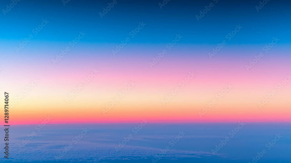 Naklejka premium A serene sky transitions from deep blue to soft pink and orange, creating a peaceful atmosphere above the clouds during sunset.