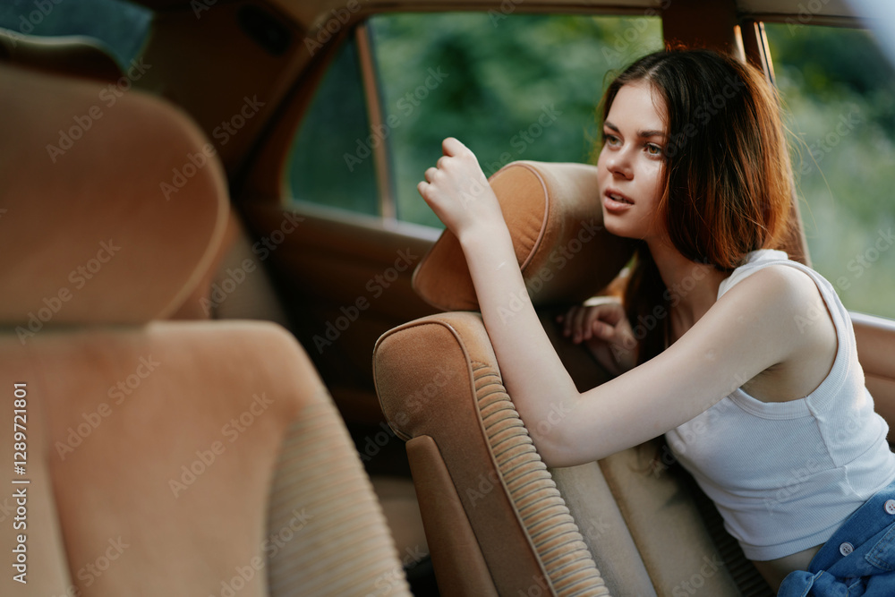 Young woman resting in a car with a relaxed expression, wearing a casual outfit, natural background and warm color tones, ideal for lifestyle and travel themes. Young woman resting in a car with a relaxed expression, wearing a casual outfit, natural background and warm color tones, ideal for lifestyle and travel themes.