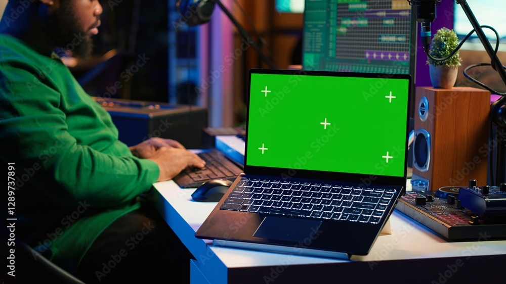 Professional artist operating on daw software in home studio, using a green screen layout next to him. Producer editing his audio recordings by applying mixing and mastering techniques. Camera A. Professional artist operating on daw software in home studio, using a green screen layout next to him. Producer editing his audio recordings by applying mixing and mastering techniques. Camera A.