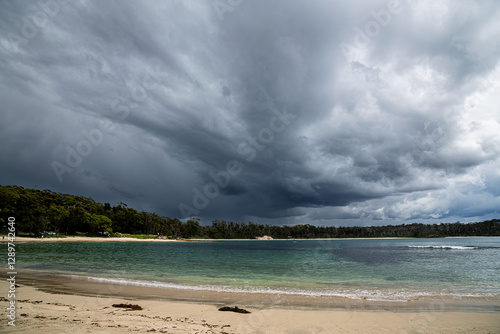 Photos Australian landscape and seascape in the late afternoon showing dark storm clouds and rain in the sky over a beautiful bay with green/blue water and sandy beach